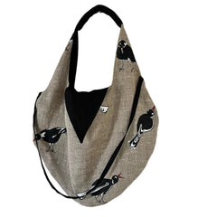 Natural linen hobo shoulder bag with soft slouchy shape and bird print, featuring a magnetic snap closure and an inner zippered pocket, eco-friendly handmade design